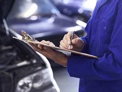 Close up of a car mechanic doing a check list on his clipboard
